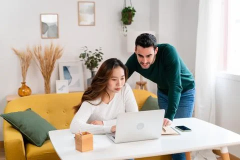 Happy couple using laptop at home Stock Photos