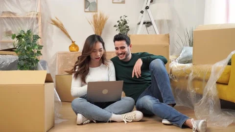Happy couple using laptop on sofa Stock Footage 237240684