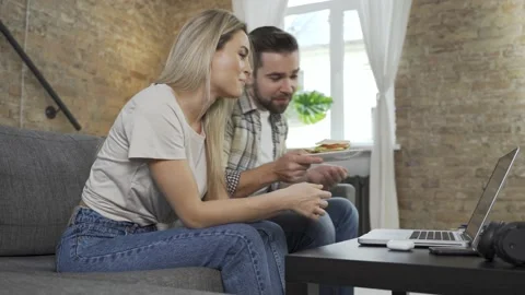 Happy couple using laptop for video call in the living room Video stock 233430883