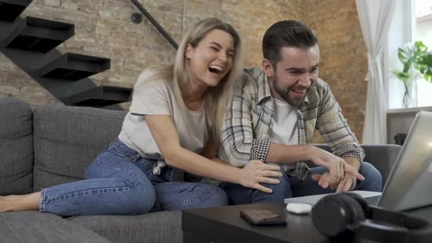 Happy couple using laptop for video call in the living room Video stock 233431428