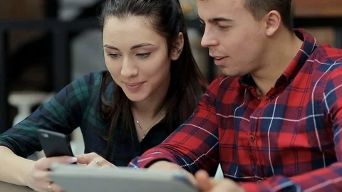 Happy Couple using smartphone and tabletPC devices eating breakfast at home Video stock 73752945