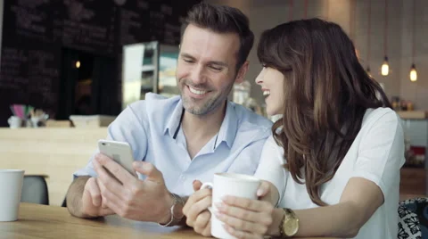 Happy couple using smartphone at cafe Stock Footage 64652831