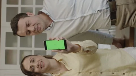 Happy couple using smartphone at dining table in kitchen. Stock Footage 204713904