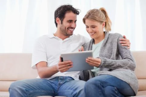 Happy couple using a tablet computer Stockfoto's