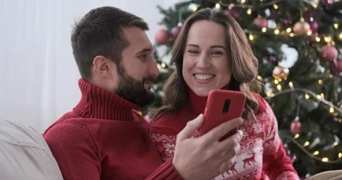 Happy couple video chatting using mobile phone during Christmas Stock Footage 129425610
