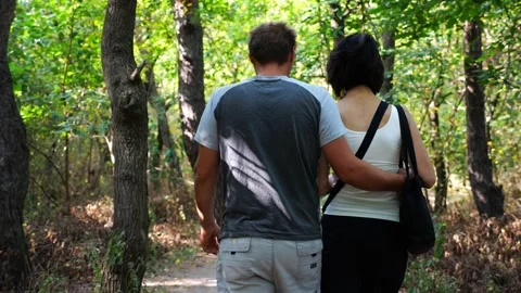 Happy couple walking along path at summer forest. Romantic pair going along trai Vídeo Stock 344041318