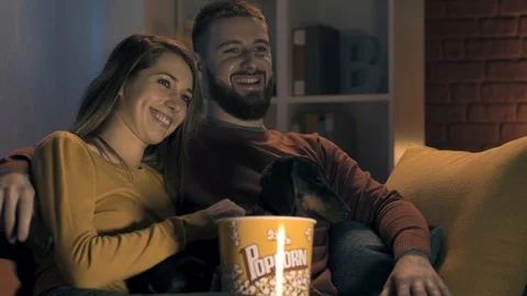 Happy couple watching TV together at home Stock Footage 128728053