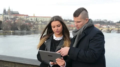 Happy couple work on tablet on the bridge - city (Prague) in background 스톡 동영상 45170923