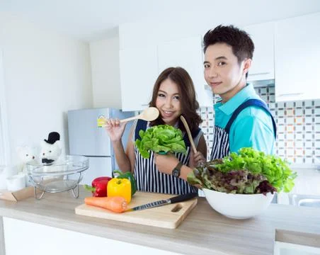 Happy couples in kitchen Stock Photos