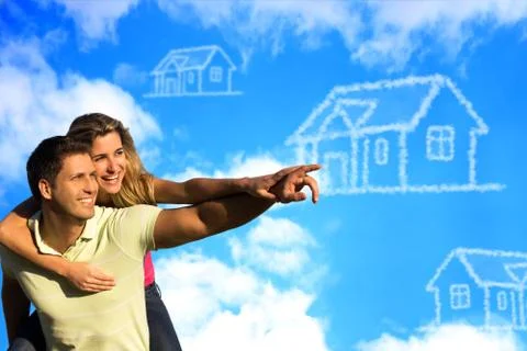 Happy coupleunder the blue sky dreaming of a house. Stock Photos