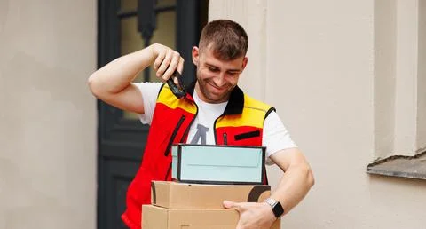 The happy courier scanning boxes a barcode packages with a handheld barcode Stock-Fotos