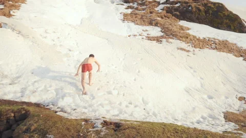 Happy crazy man in red shorts jumping in snow Stock Footage 106190861