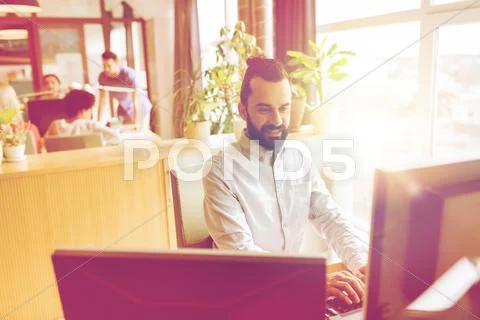 Happy creative male office worker with computer Stock Photos
