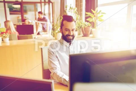 Happy creative male office worker with computer Stock Photos