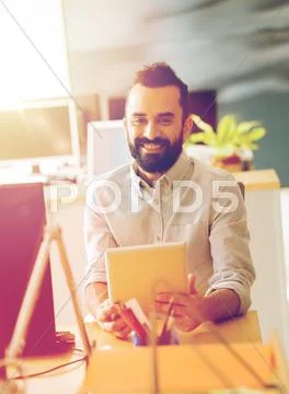 Happy creative male office worker with tablet pc Stock Photos