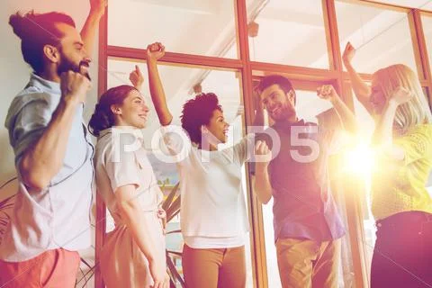 Happy creative team celebrating victory in office Stock Photos