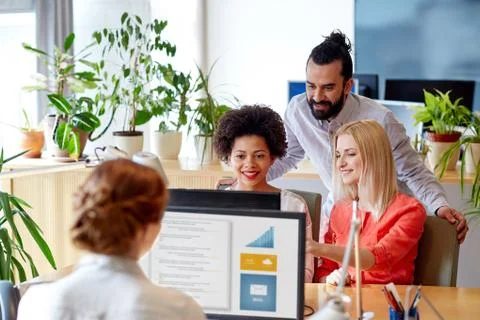 Happy creative team with computer in office Foto stock