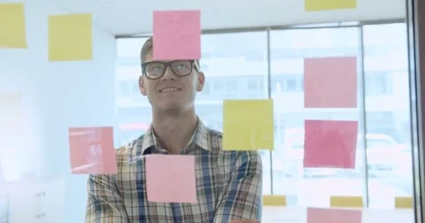 Happy creative young man working with sticky notes in the office Stock Footage 69168892