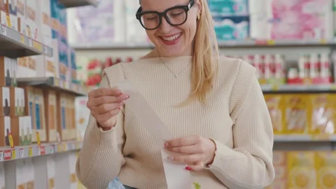 Happy customer checking a long grocery receipt Stock Footage 297850124