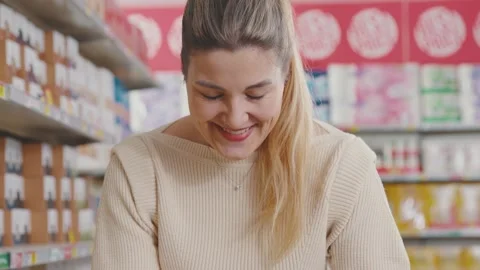 Happy customer using a smartphone at the grocery store Stock Footage 297850090