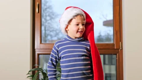 Happy cute boy in red Santa hat, holiday eve. Stock Footage 167355662