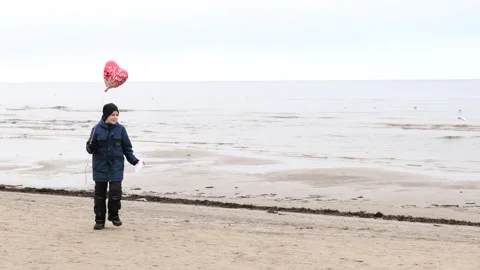 Happy cute boy standing with red ballon heart Stock Footage 145977151