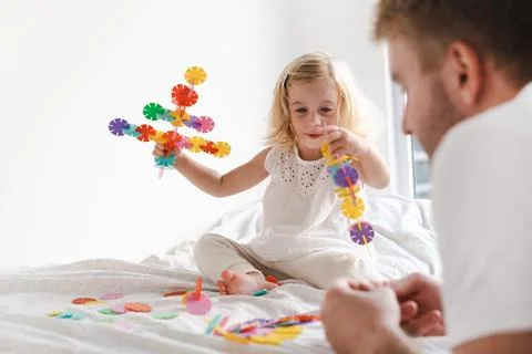 Happy cute caucasian two years old toddler, girl playing with adult, man with Stock Photos