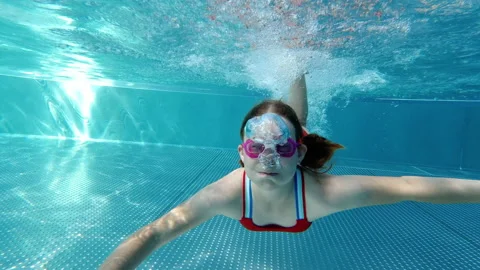 Happy cute child joyfully diving and playing in swimming pool Stock Footage 201780725