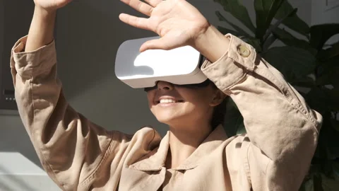 Happy cute girl using 3D virtual reality headset. Virtual reality game. Stock Footage 250403029