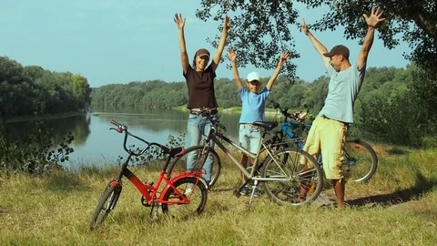 Happy cyclists on the river bank. Stock Footage