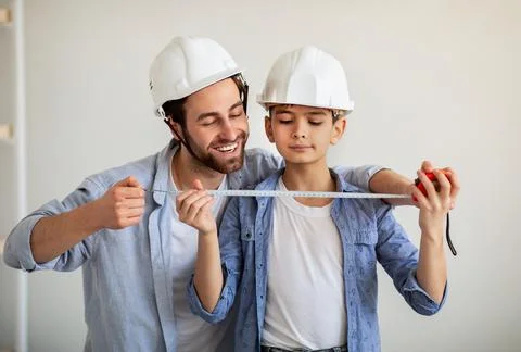 Happy dad and his son making measurements using roulette, dad teaching boy for Stock Photos