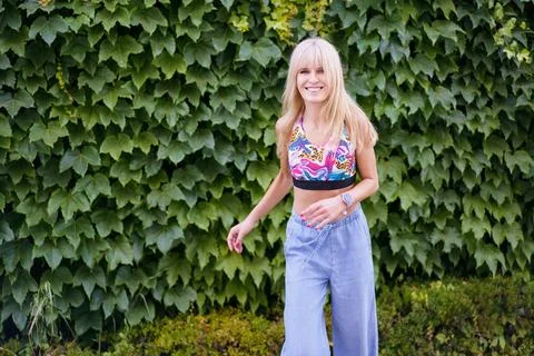 Happy dancer smiling while dancing next to an urban garden Stock Photos