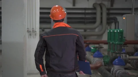 Happy dancing young engineer is in a technical room. at the factory Stock Footage 105607136