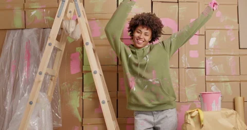 Happy dark skinned Afro American woman has fun and dances carefree dressed in Stock Footage 144919873