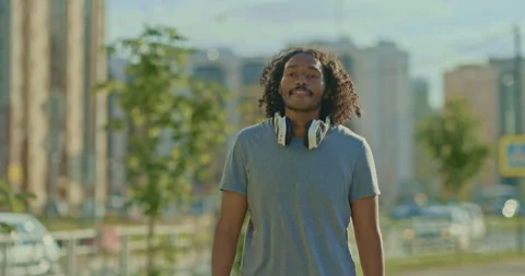 Happy dark-skinned student walks around the city, summer vacation. Young man Stock Footage 201607141