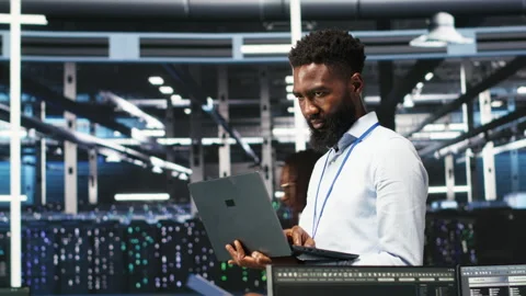 Happy data center admin uses node tree programming on laptop Stock Footage 307019517