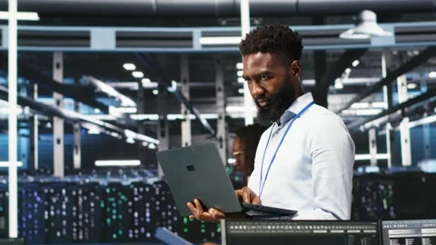 Happy data center admin uses node tree programming on laptop Stock Footage 309506032