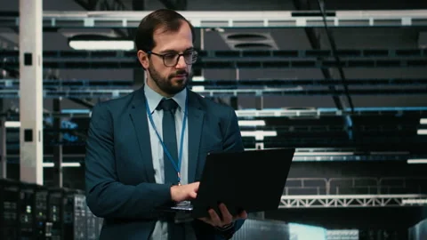 Happy data center programmer using laptop and AR tech to monitor error logs Stock Footage 329652941