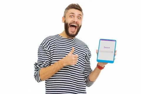 Happy delighted man enjoying using a search website Stock Photos