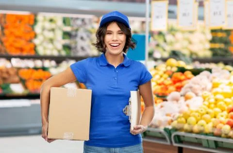 Happy delivery girl with box at grocery store Stock Photos