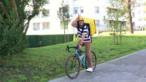 Happy delivery man waving while riding bicycle Stock Footage 318096155