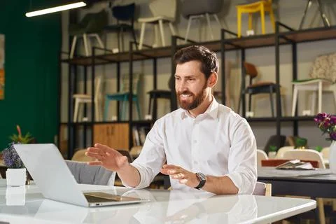 Happy designer, architect sitting at table, working, using laptop. Stock Photos