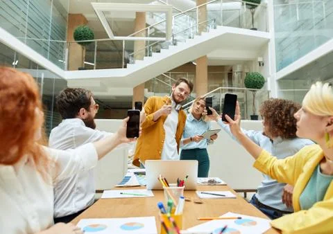 Happy designers sitting at table in creative office Stock Photos