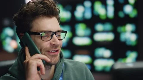 Happy developer talking smartphone at night datacenter closeup. Man ending call Stock Photos
