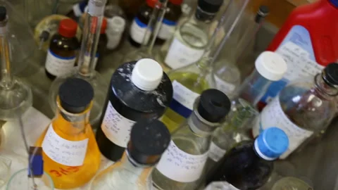 The happy disarray is on the Desk in the chemical lab. Top view of jars, flasks, Stock Footage 85615805