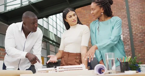 Happy diverse architects looking at architectural models at office Stock Footage 335513120