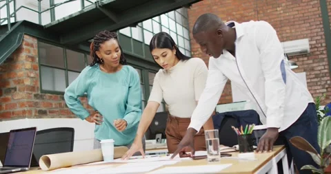 Happy diverse architects looking at architectural blueprints and discussing work Video stock 341931015