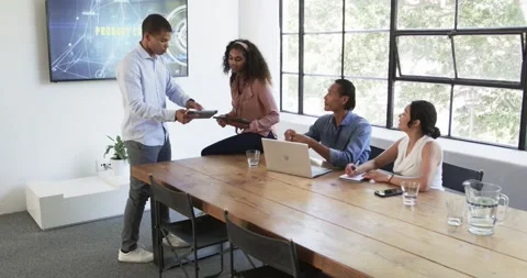 Happy diverse colleagues discussing work around laptop and celebrating in office Stock Footage 317215524