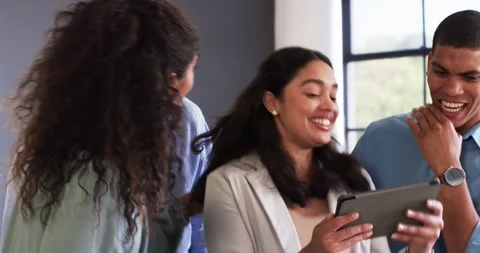 Happy diverse colleagues discussing work and using tablet and celebrating in Stock Footage 317215860