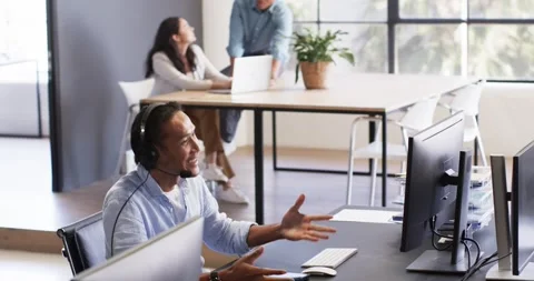 Happy diverse colleagues discussing work together around computer and Stock Footage 317215913